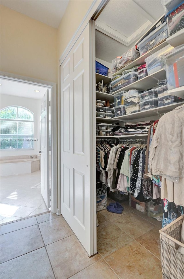 walk in closet with light tile patterned floors