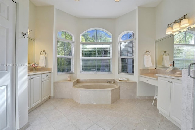 bathroom with vanity, a relaxing tiled tub, and tile patterned floors