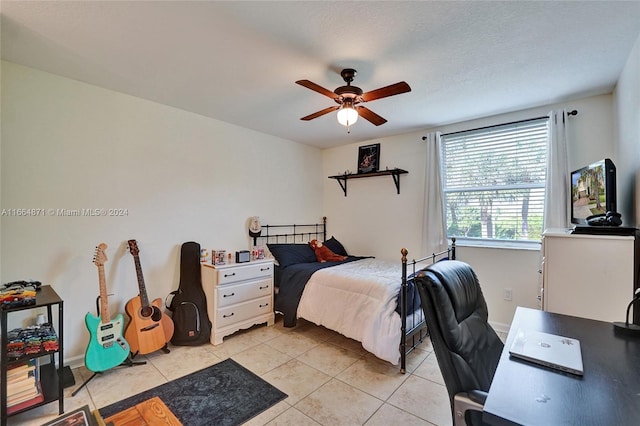 bedroom with ceiling fan, a textured ceiling, and light tile patterned flooring