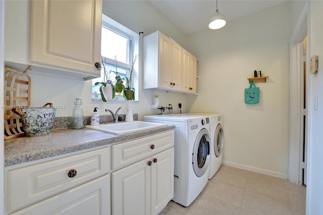 laundry area with light tile patterned floors, cabinets, sink, and washer and clothes dryer