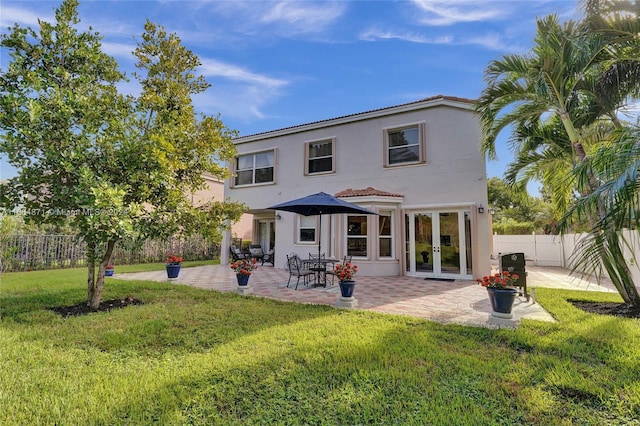 back of property featuring a patio area, french doors, and a lawn