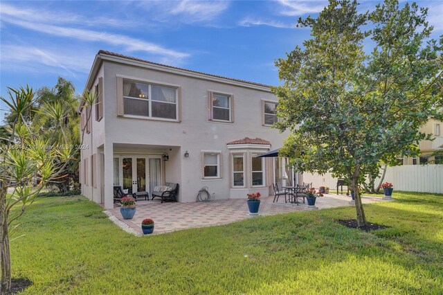 rear view of house with a yard and a patio area