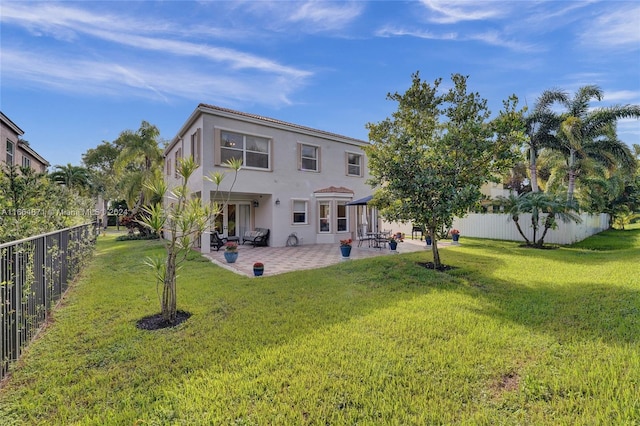 rear view of house featuring a yard and a patio