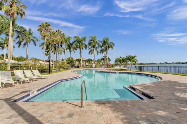 view of pool with a water view and a patio area