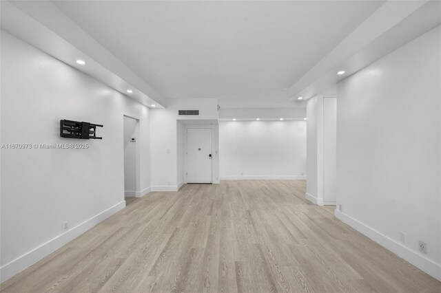 kitchen with stainless steel refrigerator, white cabinetry, light stone counters, black electric cooktop, and beverage cooler