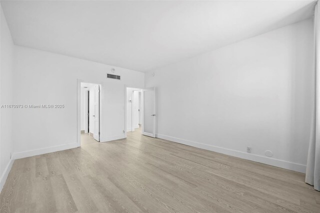 washroom featuring sink, light hardwood / wood-style flooring, and stacked washer and dryer