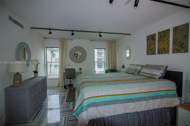 bedroom featuring ceiling fan, multiple windows, and rail lighting