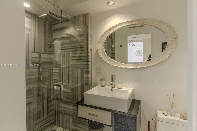 bathroom with walk in shower, vanity, and toilet