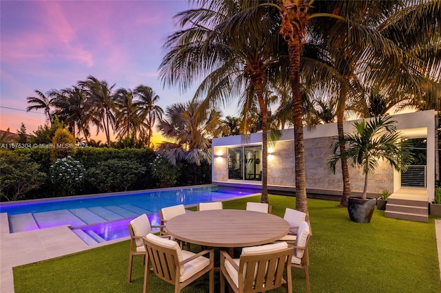 pool at dusk with a lawn