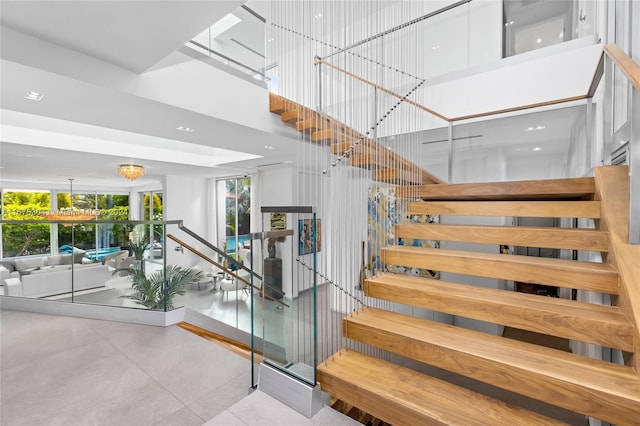 stairs featuring a chandelier and a towering ceiling