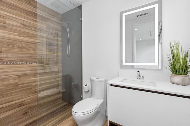 bathroom featuring vanity, toilet, walk in shower, and wood-type flooring