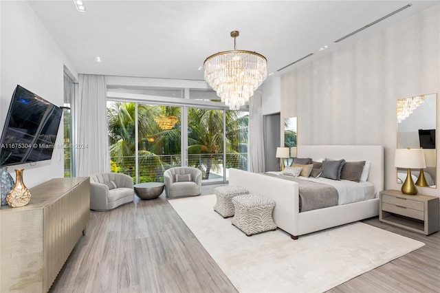 bedroom featuring a notable chandelier, hardwood / wood-style flooring, and floor to ceiling windows