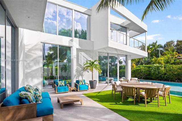 back of house with a patio, a lawn, and a balcony