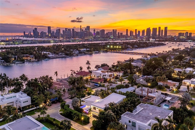 aerial view at dusk featuring a water view