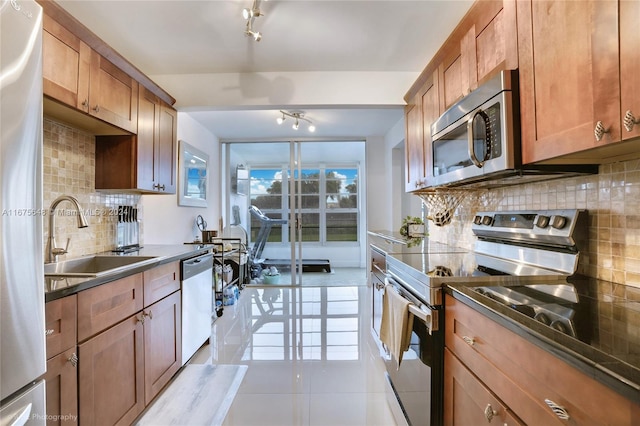 kitchen with light tile patterned flooring, decorative backsplash, an inviting chandelier, sink, and stainless steel appliances