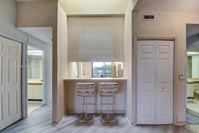 hall featuring light hardwood / wood-style floors and a textured ceiling