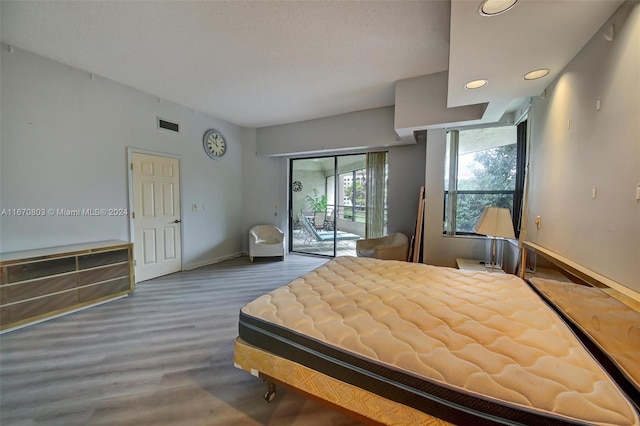 unfurnished bedroom featuring wood-type flooring and access to outside