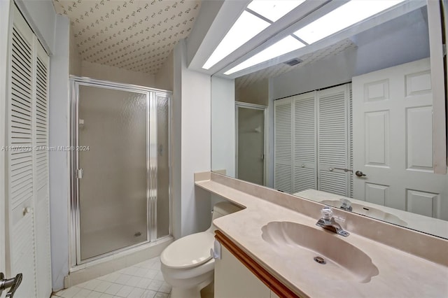 bathroom with tile patterned floors, vanity, toilet, and a shower with door