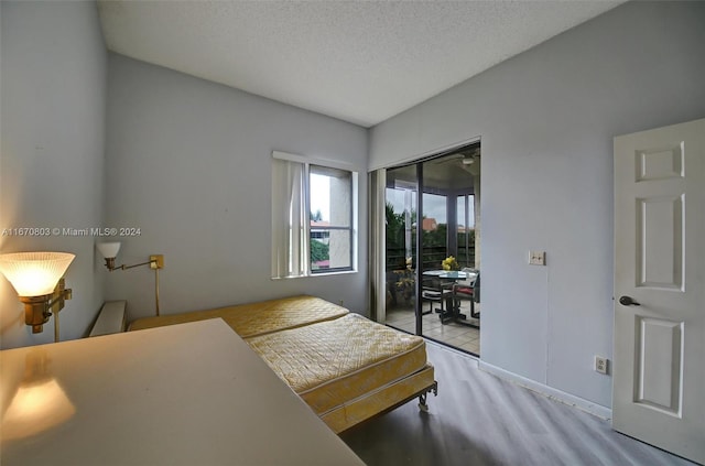 bedroom featuring a textured ceiling, light wood-type flooring, and a closet