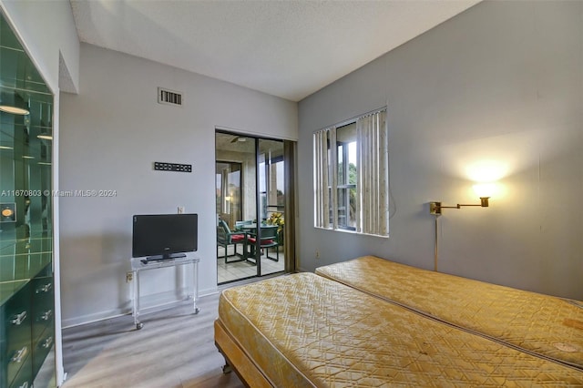 bedroom with wood-type flooring and a textured ceiling