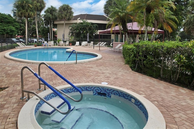 view of swimming pool with a patio area and a hot tub