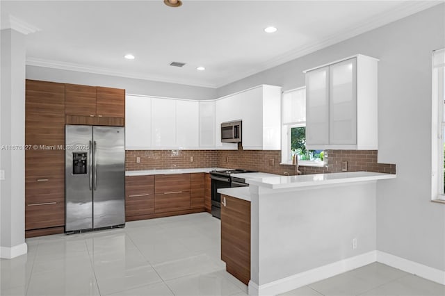 kitchen with white cabinetry, light tile patterned floors, ornamental molding, appliances with stainless steel finishes, and decorative backsplash