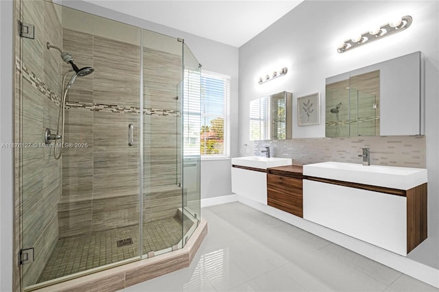 bathroom with tasteful backsplash, vanity, tile patterned floors, and a shower with shower door