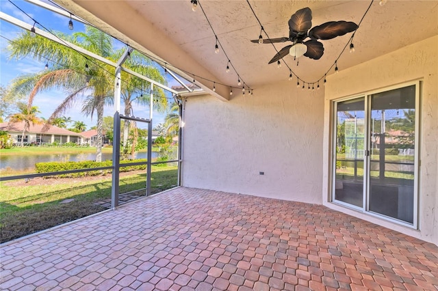 unfurnished sunroom with a water view and ceiling fan