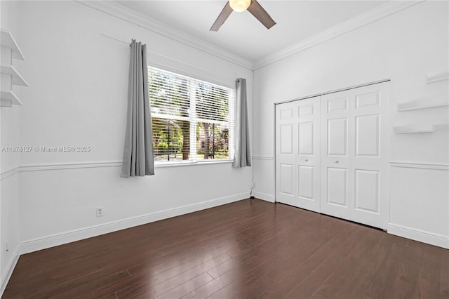 unfurnished bedroom featuring crown molding, dark hardwood / wood-style floors, ceiling fan, and a closet