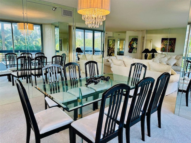 dining space featuring light carpet, a notable chandelier, and plenty of natural light