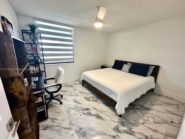 bedroom with ceiling fan and a textured ceiling