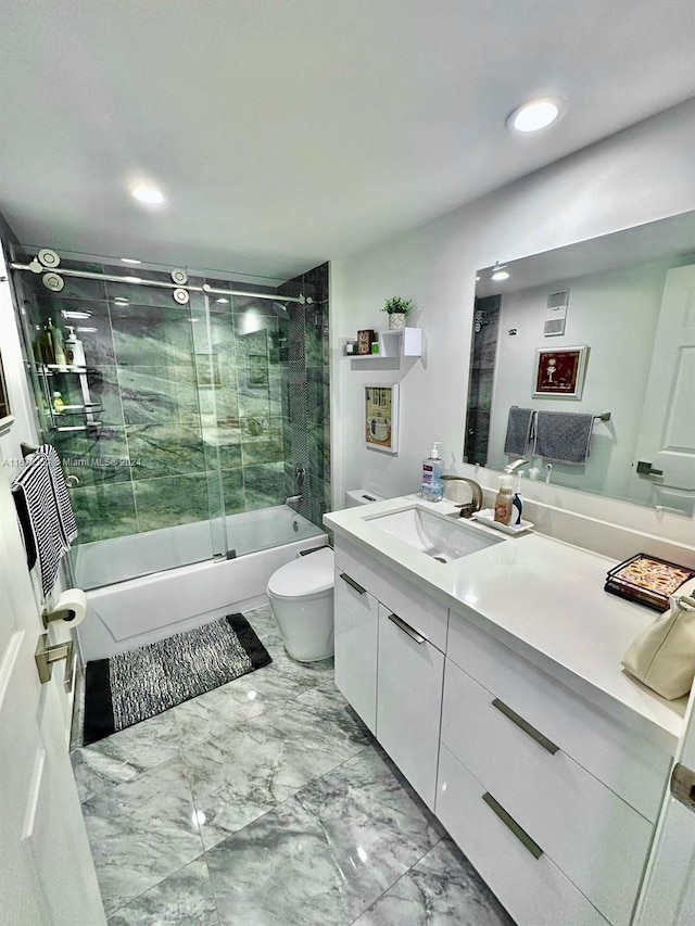 full bathroom featuring combined bath / shower with glass door, vanity, and toilet