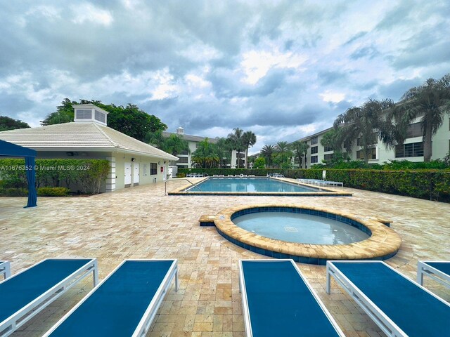 view of pool with a community hot tub and a patio area