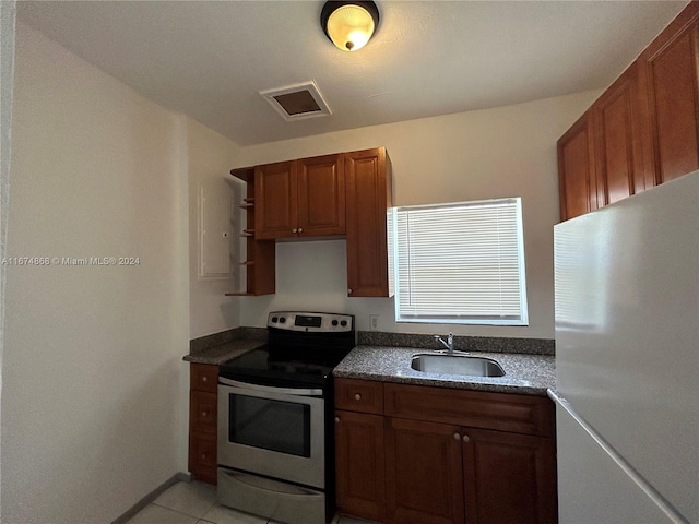 kitchen featuring fridge, sink, light tile patterned floors, and stainless steel electric range