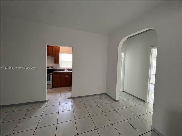 unfurnished room featuring light tile patterned floors and sink