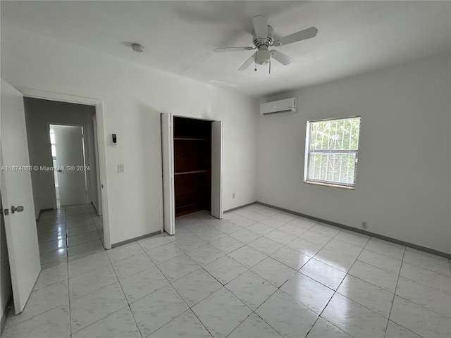 unfurnished bedroom with a wall unit AC, ceiling fan, and a closet