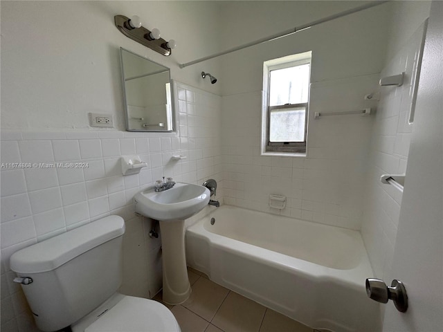 bathroom with tile patterned flooring, tile walls, toilet, and tiled shower / bath