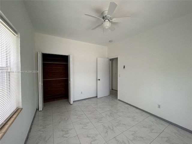 unfurnished bedroom with a closet, multiple windows, and ceiling fan