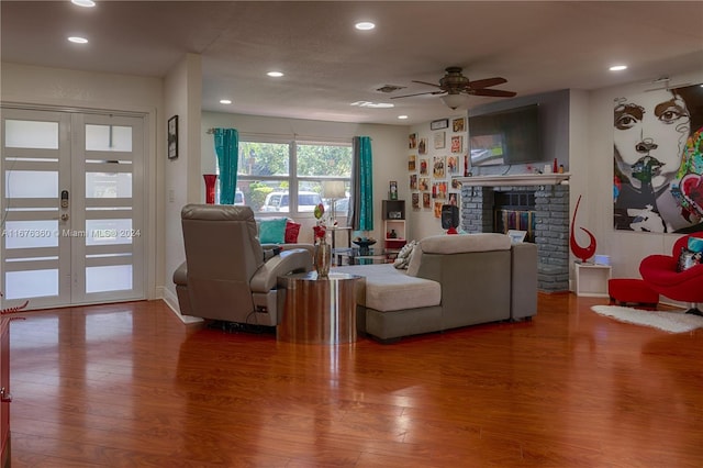 living room with ceiling fan, hardwood / wood-style flooring, a fireplace, and french doors