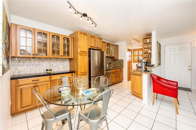 kitchen with sink, backsplash, light tile patterned floors, and stainless steel appliances