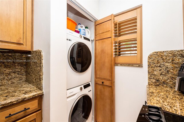 clothes washing area with stacked washer and dryer