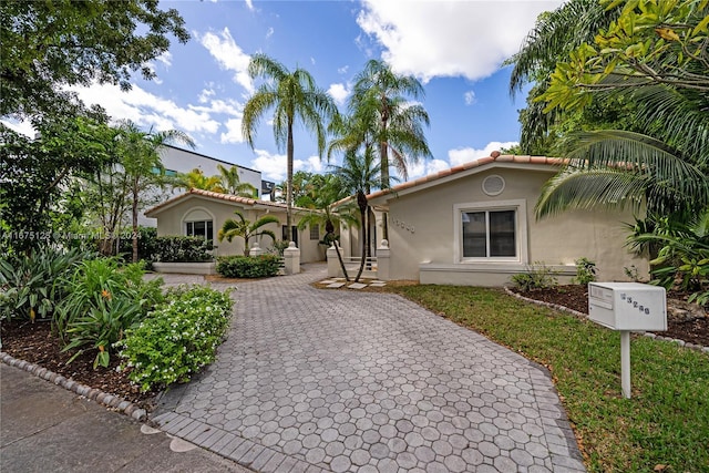 mediterranean / spanish-style house featuring a tile roof and stucco siding