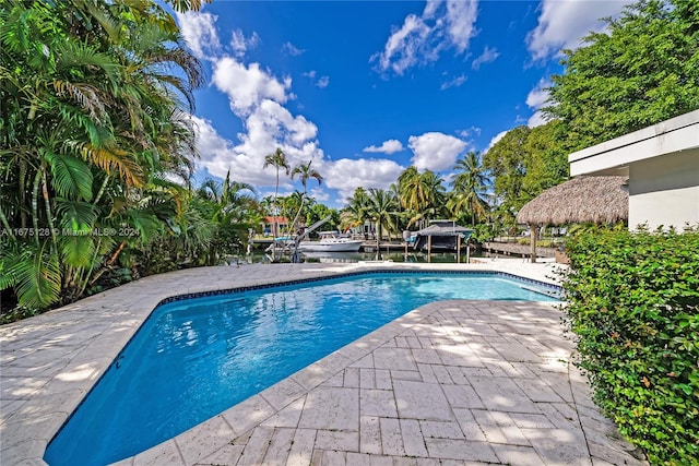 outdoor pool with a boat dock and a patio area