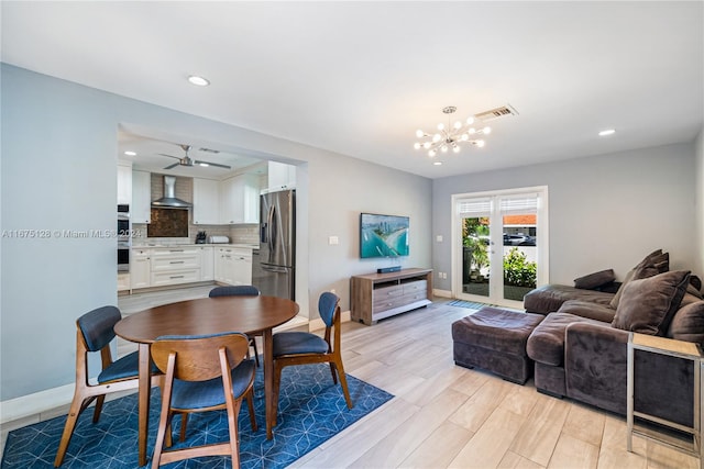 dining room with baseboards, ceiling fan with notable chandelier, light wood-style floors, and visible vents