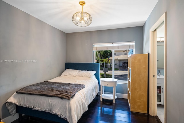 bedroom featuring dark wood-type flooring and an inviting chandelier