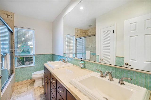 bathroom with vanity, an enclosed shower, tile walls, and toilet