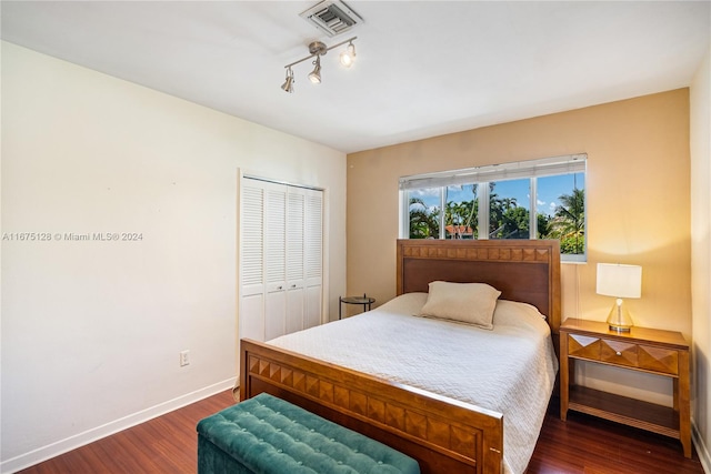 bedroom with dark hardwood / wood-style flooring and a closet