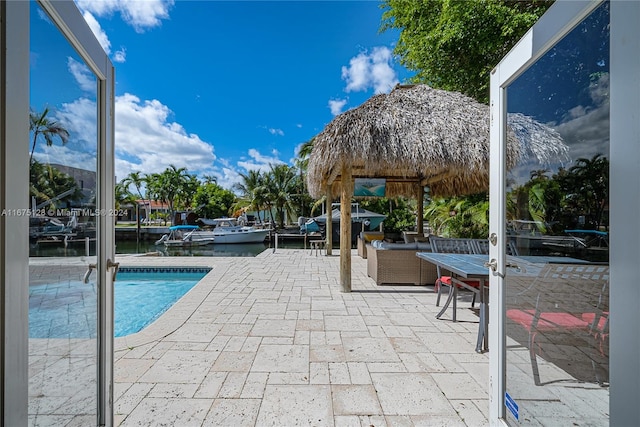 view of swimming pool with a patio and a water view