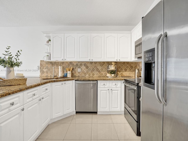 kitchen featuring dark stone countertops, sink, white cabinetry, and stainless steel appliances