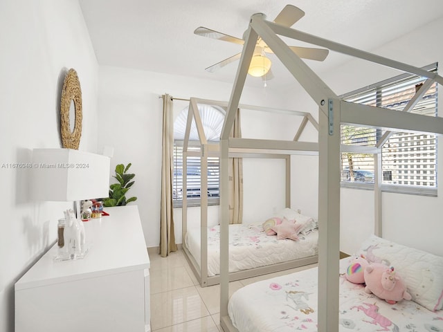 tiled bedroom featuring ceiling fan and multiple windows